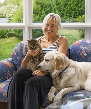 Woman at home with emotional support animals &mdash; cat and golden retriever